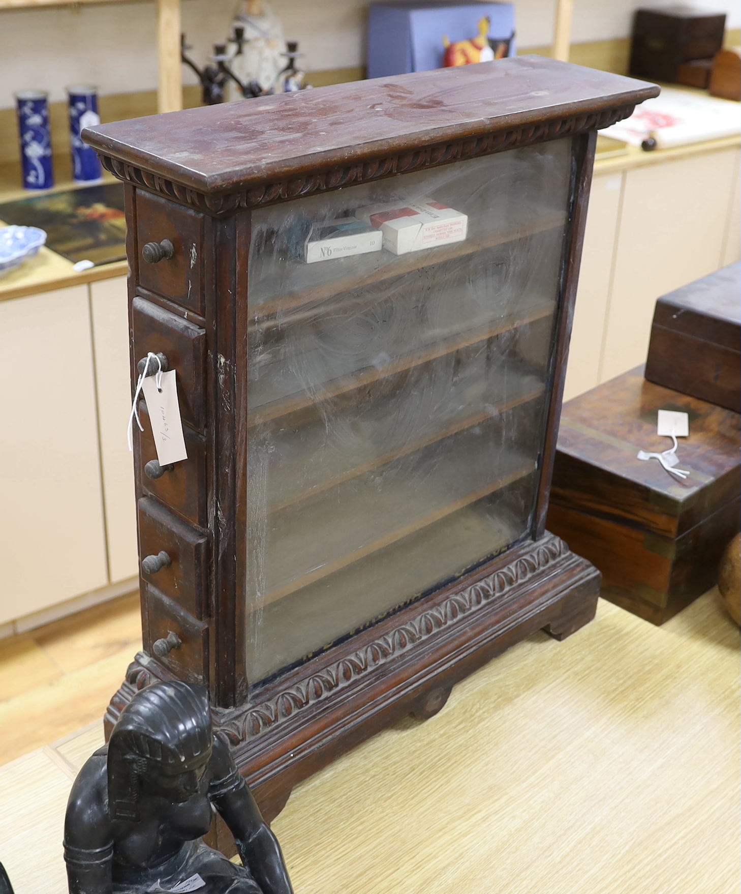 A glazed and carved mahogany cigarette shop display cabinet with remnants of gold lettering to the front, GA Mossman, Hastings stamp to the reverse, 61cm high